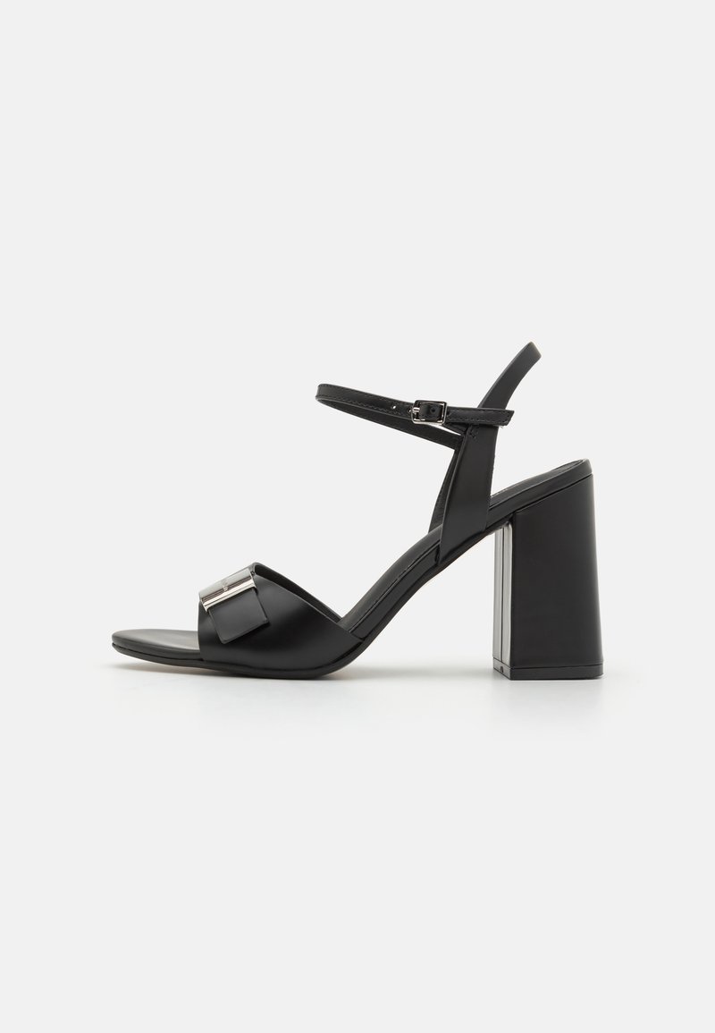 Black high-heeled sandal with a wide block heel, adjustable ankle strap, and a front strap featuring a metallic accent detail.