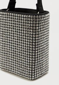 Juodas rankinukas, padengtas blizgančiais, kvadratiniais deimantais, išdėstytais tinklelio raštu, su stačiakampiu pavidalu ir tvirtais juodais dirželiais.