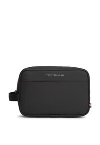 Μαύρο ορθογώνιο τσαντάκι καλλυντικών με λογότυπο Tommy Hilfiger, πλευρική λαβή και μικρό κόκκινο, λευκό και μπλε ετικετάκι στην δεξιά άκρη.