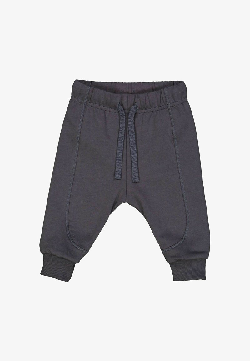 Šedé tepláky vyrobené z měkké látky s elastickým pasem, detaily na šňůrce a žebrovanými manžetami. Obsahují boční švy jako akcenty.