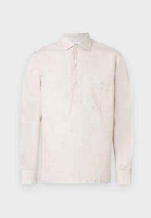 Svijetlo bež košulja dugih rukava izrađena od teksturiranog tkanja, s kopčom na gumbe, ovratnikom i jednim džepom na prsima.