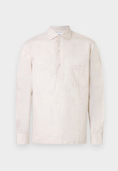 Ανοιχτό μπεζ μακρυμάνικο πουκάμισο από υφασμάτινη υφή, με κουμπωτή ραφή, γιακά και μία μονή τσέπη στο στήθος.