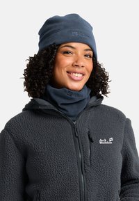 Marineblaues Fleece-Mütze und Halswärmer kombiniert mit einer dunkelgrauen Fleecejacke mit Reißverschluss und Logo, die strukturierte Materialien präsentiert.