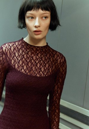 Malvefarbenes Spitzenkleid mit langen Ärmeln und hohem Kragen, das ein florales Muster und eine figurnahe Silhouette aufweist. Glatter Stoff mit texturierten Details.