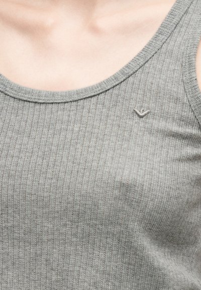 Közeli kép egy bordázott szürke ujjatlan felsőről, melyen a mellkas felső részén egy kis hímzett logó látható.