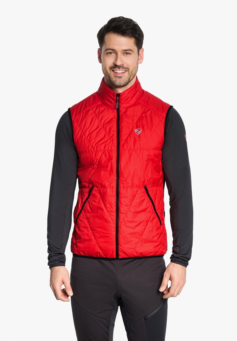 Red quilted vest with high collar, front zip closure, and two zippered side pockets. Worn over a black long-sleeve shirt.