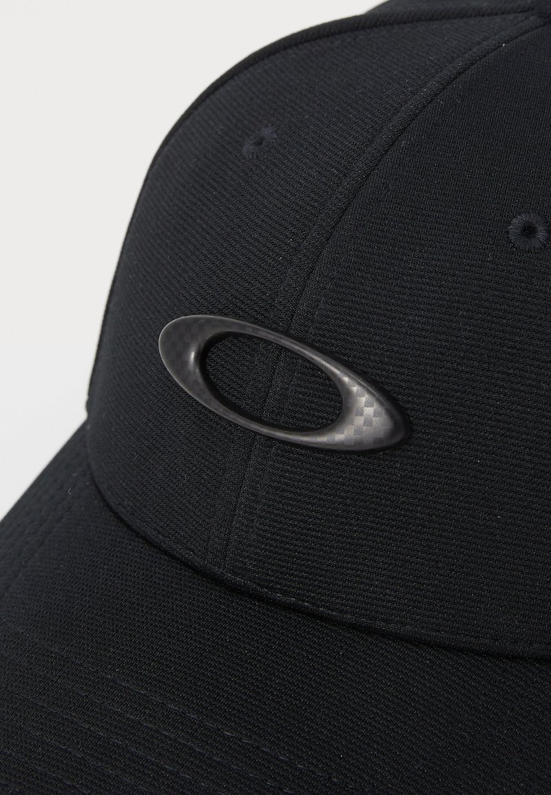 Casquette noire en tissu texturé, ornée d'un accent logo en fibre de carbone, avec une visière courbée et des détails brodés.