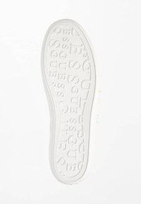 Sole in gomma bianca per sneaker, con texture a motivo rialzato che forma la scritta "GUESS". Bordi lisci e leggera curvatura sul tallone. Design minimalista.