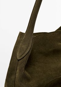 Olivgrön mocka tote-väska med ett platt, sydd handtag och en mjuk yta. Designen har rena linjer och en minimalistisk silhuett.