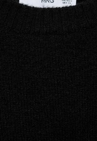 Maglione nero lavorato a maglia con una finitura testurizzata e una scollatura a coste, con un'etichetta di cura cucita nel colletto.