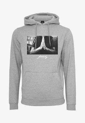 Grauer Kapuzenpullover mit einer vorderen Tasche, der ein schwarz-weißes Foto von Händen in Gebetsposition und das Wort "pray" in weißer Schrift darunter zeigt.
