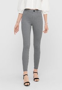 Zwart-witte legging met een houndstooth patroon, voorzien van een aansluitende silhoeet, hoge taille en een zachte textuur.