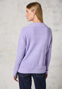 Pull en maille lavande avec une coupe ample, doté d'un col rond, de manches longues et d'un ourlet côtelé, texturé avec un tissu léger et doux.