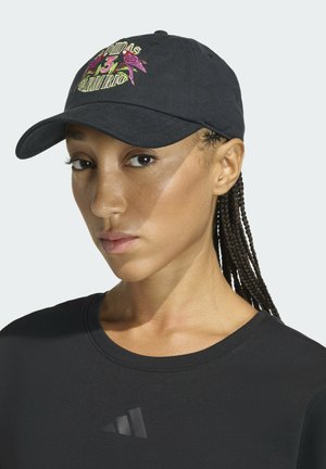 Gorra negra con gráfico bordado de pájaros rosas y texto, hecha de algodón. Visera redondeada y correa ajustable en la parte trasera.