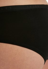 Boxer in cotone nero con una texture morbida, caratterizzati da una cintura liscia sulla quale è stampato "FALKE" in un tono sottile.