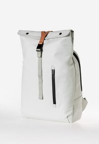 Weißer Rolltop-Rucksack aus strapazierfähigem Material, mit einem hellbraunen Lederriemen, seitlichem Reißverschlussfach und grauen Akzenten.