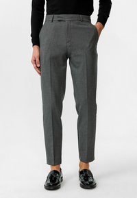 Grijze op maat gemaakte broeken met een gladde textuur, voorzien van een platte voorkant, twee zijzakken en een slim fit. Gecombineerd met zwarte gepolijste schoenen.