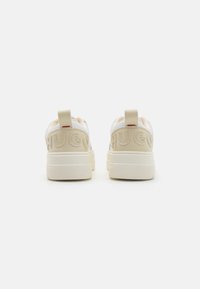 Sneaker bianchi e beige con suola testurizzata, con il logo "HUGO" impresso sul retro e una linguetta per una facile calzata.