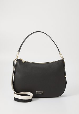 Black leather handbag with curved shape, gold zipper, and logo plate. Includes a detachable strap featuring black and white color blocking.