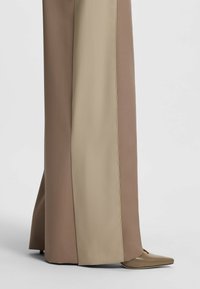 Wijd uitlopende broeken in een bicolor ontwerp met lichtbeige en taupe kleuren. Gladde stof met een nette afwerking en een zijsplit onder de knie.