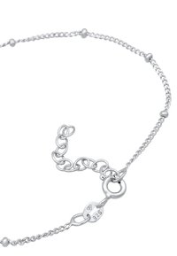 Silverfärgad kedjearmband med växelvis släta pärlor och länkar. Lås med en tagg märkt "925" för silverinnehåll. Elegant, minimalistisk design.