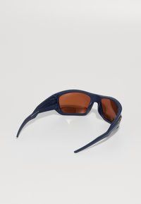 Námorně modré sluneční brýle s oranžovými skly, aerodynamický design a texturované postranní ramena s detaily loga.