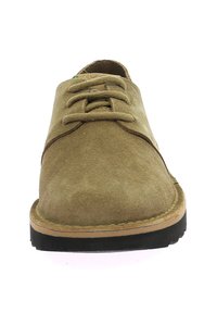 Zapatos de ante marrón con cordones, punta redonda y detalles de costura. Suela de goma y acento en el borde en contraste con el color tostado en la suela.