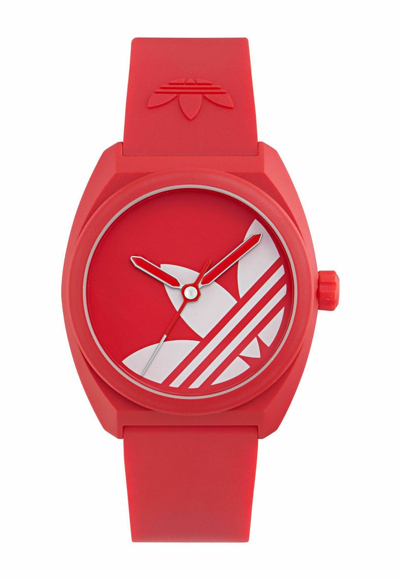 Rødt silikoneur med rund urskive, hvidt Adidas-logo, hvide timeindeks og røde time- og minutvisere. Drejekrone på siden.