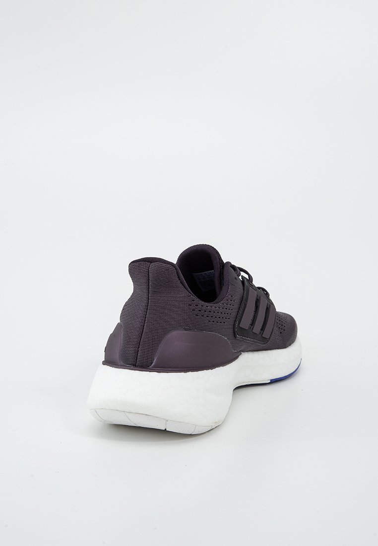 Chaussure de sport violette foncée avec tige en textile, semelle en mousse, trois rayures noires et un design arrière texturé. Elle possède un col rembourré.