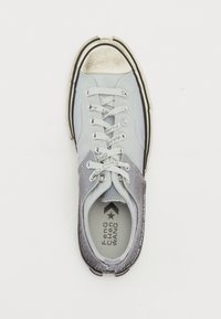 Hellblau und grau Sneaker mit einer abgenutzten silbernen Zehenkappe, weißen Schnürsenkeln und schwarzem Außensohle. Verfügt über strukturierte Einsätze und Logo-Details.