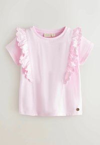 Maglietta rosa chiaro a maniche corte per bambini con dettagli arricciati lungo i lati anteriori e un piccolo logo metallico rotondo vicino all'orlo.