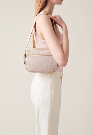 Piccola borsa strutturata in materiale testurizzato beige chiaro con dettagli color marrone, dotata di una chiusura con zip superiore e una tracolla.