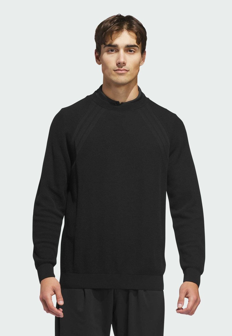 Black knitted sweater with a high neckline, ribbed cuffs, and textured pattern. Features raglan sleeves and a straight hem.