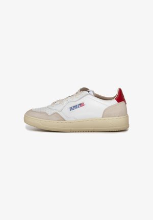 Zapatilla de cuero blanca y beige con acentos rojos, puntera perforada y logo en el lateral. Suela acolchada para mayor comodidad y tracción.