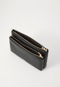 Borsa in pelle nera con due scomparti con cerniera, dotata di hardware dorato, superficie texturizzata e forma rettangolare.