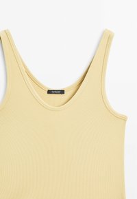 Lys gul ribbet tanktop med rund halsudskæring og brede skulderstropper. Mærket læser "Massimo Dutti," hvilket angiver mærkets oprindelse.