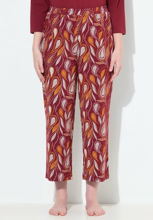 I pantaloni di colore marrone con motivo paisley in arancione e bianco presentano una vita elastica. Il tessuto sembra leggero e dalla consistenza liscia.