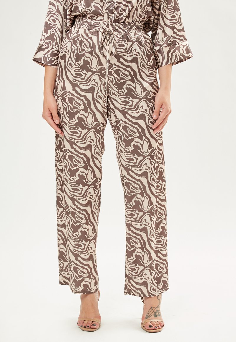 Bruine en crème gestreepte broek met een relaxte pasvorm, elastische tailleband en koorddetail. Gemaakt van lichte stof.