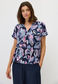 Blusa a maniche corte di colore navy con un motivo floreale che presenta tonalità di rosa, blu e crema; ha un collo a V e una vestibilità ampia e rilassata.