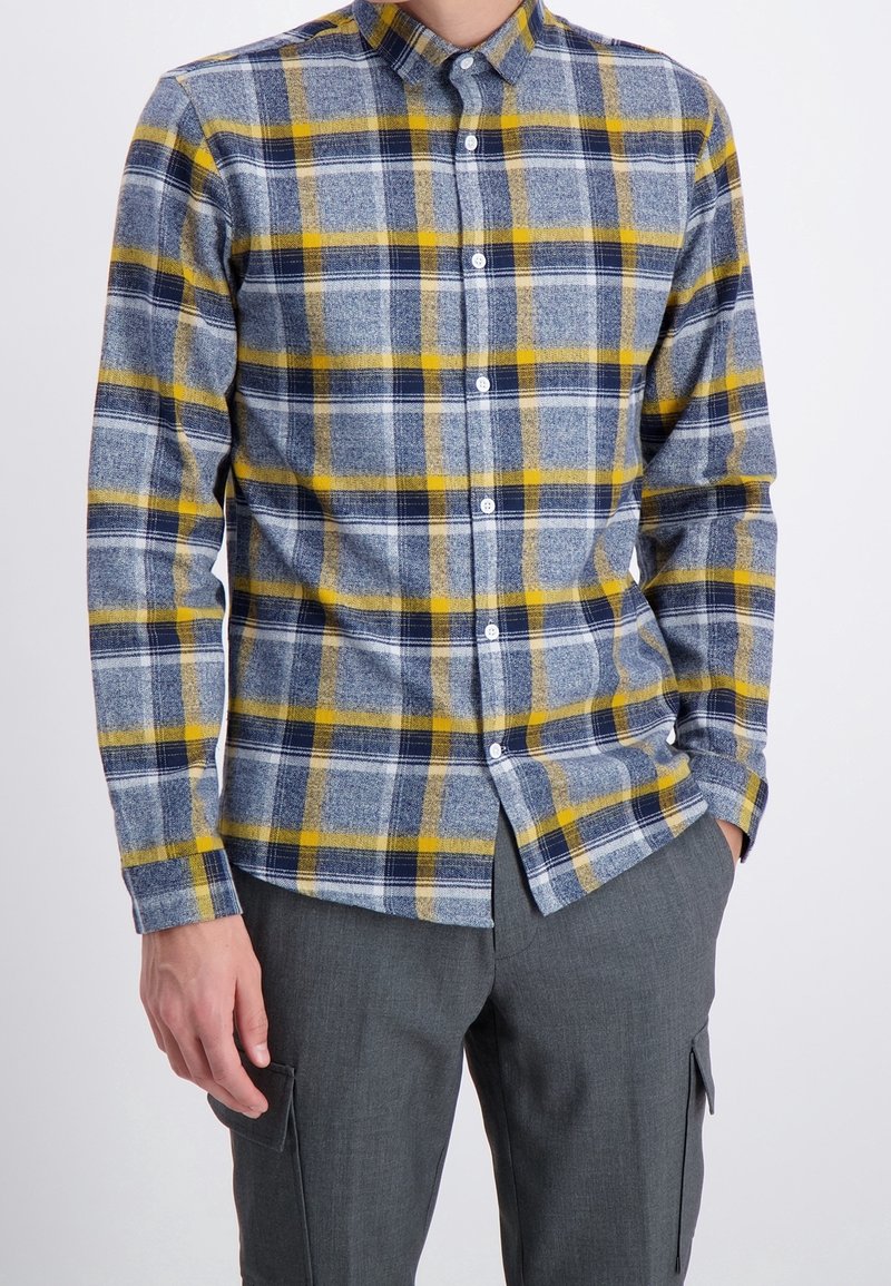 Langsleevige blouse met een blauw, geel en grijs ruitpatroon. Gemaakt van een textuurstof met een standaard kraag en knopen.