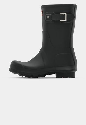 Cizmă de cauciuc neagră pentru ploaie, cu vârf rotunjit, talpă texturată pentru aderență, detaliu cu cataramă pe lateral și finisaj neted.