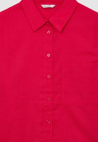 Camicia button-up rosa brillante realizzata in tessuto testurizzato, con colletto, sei bottoni e una tasca sul petto. Design semplice e funzionale.