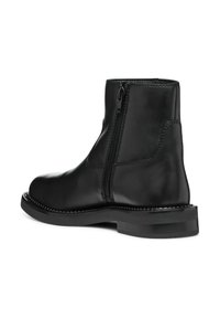 Black leather ankle boot with side zipper, smooth texture, rounded toe, and stitched accents on the sole. Durable rubber outsole.