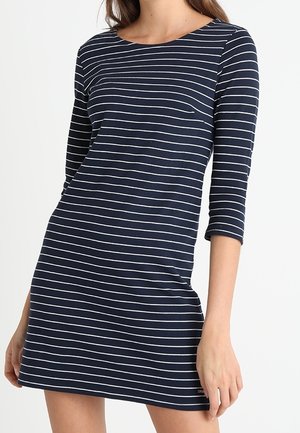 Granatowa sukienka w białe poziome paski, okrągły dekolt, rękawy o długości trzy czwarte, dopasowany krój oraz dół, który kończy się powyżej kolan.