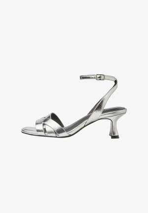 Silverfärgade metalliska sandaler med klack, med en elegant design, som har ett smalt vristband och en blygsam konformad klack. Slät yta.