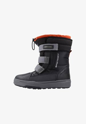 Bota de invierno negra con forro naranja, cuenta con tres correas grises, diseño impermeable y suela de goma texturizada para tracción.