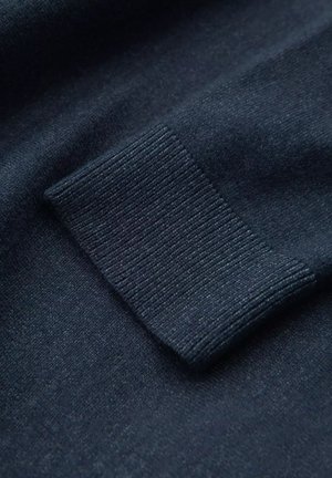 Granatowa dzianina z detalem ściągacza. Materiał wydaje się miękki, o gładkiej teksturze i delikatnym połysku.