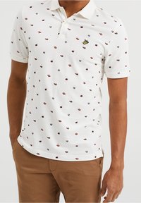 Bílá polokošile s malými multicolor vzory, s knoflíkovou légou a krátkými rukávy. Ozdobena žlutým vyšívaným logem.