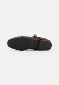 Scarpa piatta in stampa leopardata con tomaia in suede, suola in gomma nera e un piccolo dettaglio con fibbia su una fascia larga che attraversa il piede.