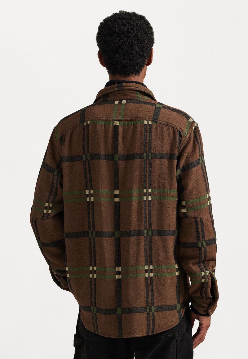 Camicia a quadri marrone con accenti verdi e neri, dotata di colletto e polsini abbottonati. Tessuto morbido e vestibilità rilassata.